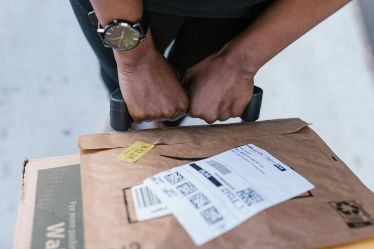 Close-up of delivery worker handling a package with care outdoors.