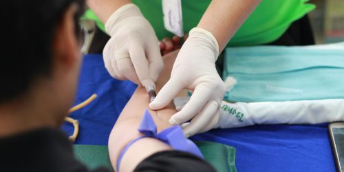A healthcare professional administering an injection to a patient's arm during a medical procedure.